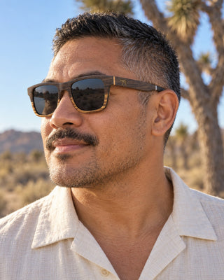 Joshua Tree polarized sunglasses worn by a man beside a Joshua tree in the high desert