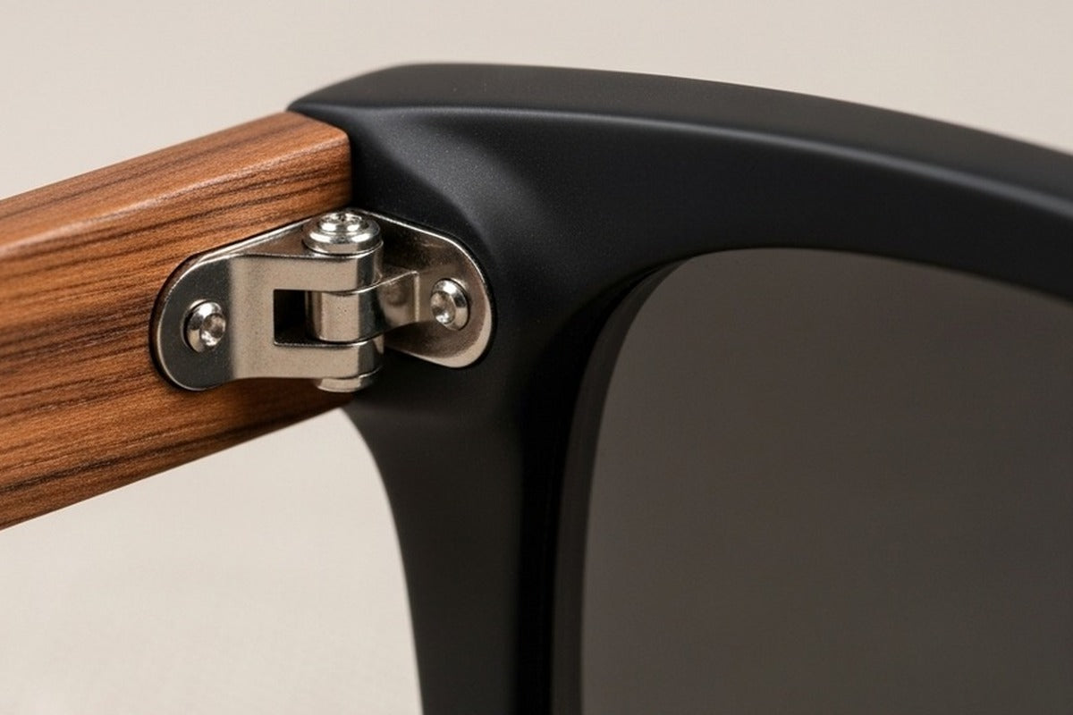 Macro detail of brushed stainless steel hinge mechanism on wood frame — Cali Life Co construction detail