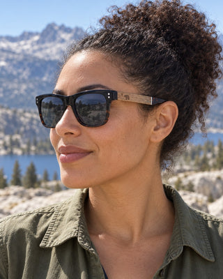 Pyramid Peak polarized sunglasses worn by a woman on a granite ridge in the Desolation Wilderness